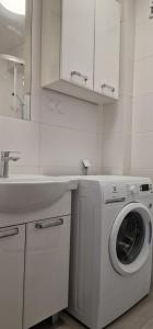 a white kitchen with a washing machine and a sink at Hostel Berberysowa in Wrocław