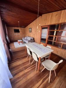 a dining room with a table and chairs and a couch at Casa Luma in Puerto Montt +4 photos