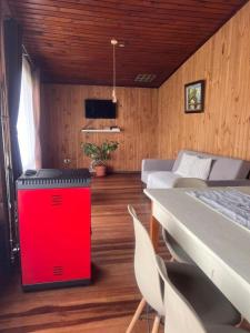 une pièce avec une glacière rouge dans une pièce avec des chaises dans l'établissement Casa Luma, à Puerto Montt