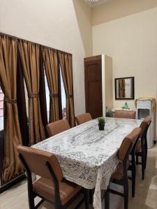 a dining room with a white table and chairs at Rumah Cahaya Syariah Guesthouse in Rampal