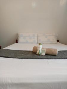 a bed with two towels and two bottles on it at Filmegs Seaside in Alegria