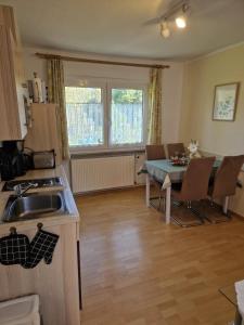 a kitchen with a sink and a table at Ferienwohnungen Christine Knoll in Bad Frankenhausen