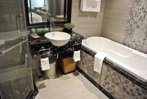 a bathroom with a sink and a bath tub at JB Serviced Apartment in Hanoi