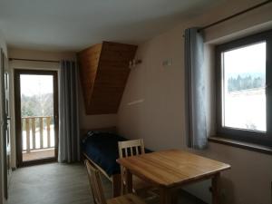 a dining room with a table and a window at Domek pod Koroną Bieszczad in Strzebowiska