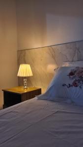 a bedroom with a bed with a lamp on a night stand at Apartamento no centro de Boa Vista in Boa Vista