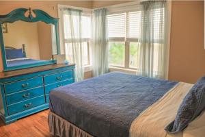 a bedroom with a blue dresser and a mirror at Home Away from Home 2 bedroom house in Bay City