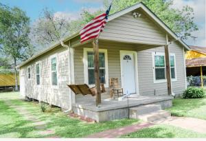 a small house with an american flag on the porch at Home Away from Home 2 bedroom house in Bay City