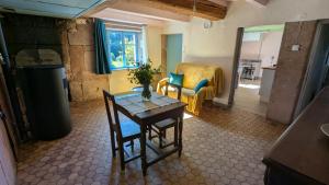 ein Wohnzimmer mit einem Tisch und einem Stuhl in der Unterkunft Le Chalet Vosges Montagne in Le Tholy