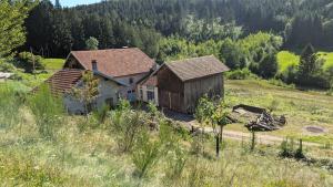 Ein altes Haus mitten auf einem Feld in der Unterkunft Le Chalet Vosges Montagne in Le Tholy