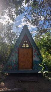 a small house with a door in a forest at Tiny Room in Passagem