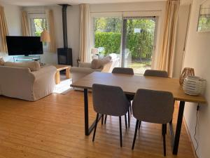 a living room with a wooden table and chairs at Landhuis Sint Nyk in Sint Nicolaasga