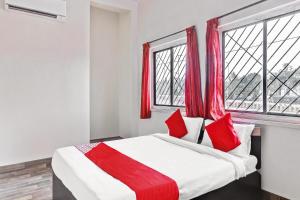 1 dormitorio con 1 cama grande y cortinas rojas en Hotel O Shree Balaji Lodging, en Chikalthān