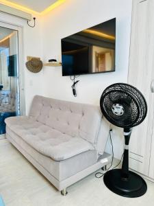 a living room with a white couch and a fan at Aves de Laguna Beach in Trementino