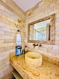 a bathroom with a stone sink and a mirror at Aves de Laguna Beach in Trementino
