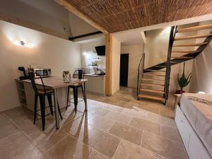 a room with a table and a kitchen and a staircase at Gîte les Millères - Le Duplex Cosy in Villemur-sur-Tarn
