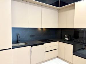 een keuken met witte kasten en zwarte apparaten bij Avenue Boutique Luxury N4 in Chişinău