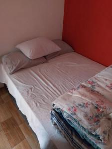 een onopgemaakt bed met een kussen en een deken erop bij Casa para alugar in Paraty
