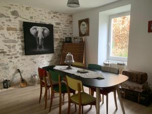 a dining room with a table and chairs and an elephant painting at MAISON DE VILLE à Saint-Junien in Saint-Junien