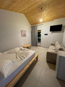 a bedroom with a large bed and a couch at Agrotourism Isak in Finiq