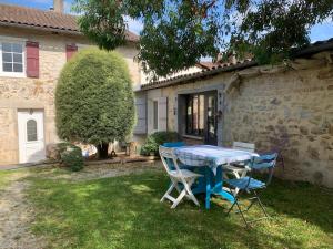 a table and chairs in front of a house at MAISON DE VILLE à Saint-Junien in Saint-Junien
