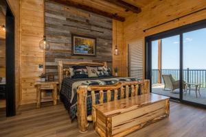 ein Schlafzimmer mit einem Bett und einer Holzwand in der Unterkunft Skyfall Lodge by American Patriot Getaways in Park Settlement + 89 Fotos