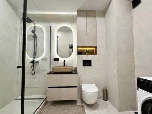 een badkamer met een toilet, een wastafel en een spiegel bij Avenue Boutique Luxury N4 in Chişinău +5 foto's