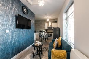 een woonkamer met een blauwe accentmuur bij Central 2 Bed Apartment Perfect for Long and Short Stays in Southampton