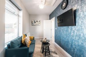 a living room with a couch and a clock on a wall at Shirley 2 Bed Apartment in Southampton