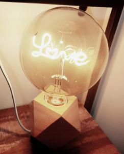 a glass lamp with writing on it sitting on a table at Le refuge de Bergheim - Proche Colmar - Sur la route des Vins - Studio de luxe avec Jacuzzi Privatif in Bergheim +2 photos
