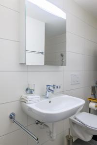 a white bathroom with a sink and a mirror at Casa Rheinblick - Apartment C in Basel +16 photos