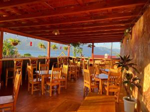 a restaurant with wooden tables and chairs on a patio at Casa del Abuelo in San Pedro La Laguna