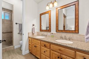 un baño con dos lavabos y dos espejos en Leisure Landing Unwind In The Pines, en Shaver Lake 41 fotos más