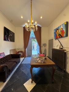a living room with a chandelier and a table at La Maison de la Duchesse de la Vallière - Parking privé gratuit in Mons
