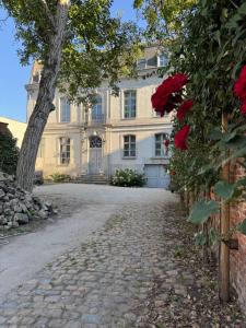 a large white house with a tree and a driveway at La Maison de la Duchesse de la Vallière - Parking privé gratuit in Mons +7 photos