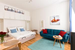 ein Wohnzimmer mit einem Bett und einer blauen Couch in der Unterkunft MALIXA - Apartment in the heart of Vienna next to Metro in Wien