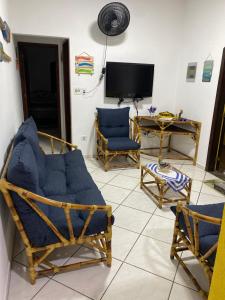 ein Wohnzimmer mit zwei Stühlen und einem Fernseher in der Unterkunft Casa térrea em Caraguatatuba in Caraguatatuba