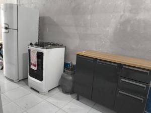 a kitchen with a stove and a refrigerator at Quarto em lugar tranquilo e bem localizado in Barueri