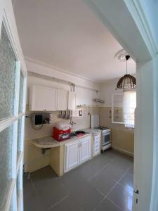 a small kitchen with white cabinets and a table at Dany house in 'Aïn el Turk