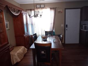 Un comedor con mesa y sillas y una ventana. en Be Our Guest, en Charlotte