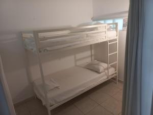 a small white bunk bed in a room at Apartamento para 4 pessoas in Cabanas de Tavira