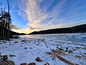 a beach with snow on the shore of a river at Three level cabin with Hot Tub in Duck Creek Village