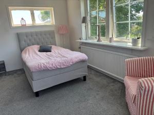 a bedroom with a bed and a window and a chair at Villa Fredsstigen in Åmål
