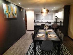 a dining room with a table and chairs and a kitchen at Gracious Beauty in Bloemfontein