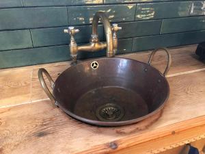 a copper sink with a faucet on a wooden counter at Rosies in Liskeard +25 photos