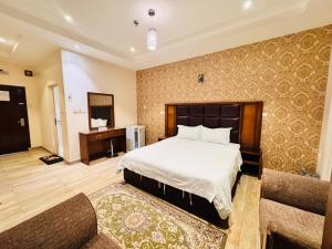 una habitación de hotel con una cama y un sofá en رفاء الذهبية للشقق المخدومة, en Al Makhwāh