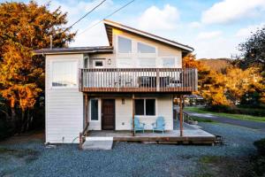 a house with a deck and two chairs on a driveway at Ocean Oasis in Rockaway Beach