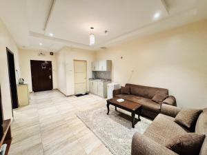 una sala de estar con un sofá y una mesa en رفاء الذهبية للشقق المخدومة, en Al Makhwāh