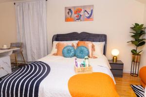 a bedroom with a bed with orange and blue pillows at Luxury Vibes ,Cozy Location in East Orange +6 photos