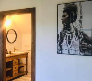 ル・ホーヴァルトにあるLa Maison d Ange Louの壁に女性の写真が飾られたバスルーム