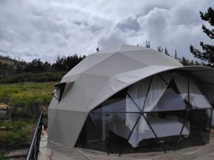 a white tent with a chair in a field at Sweet Forest- Domo Luna in Punilla